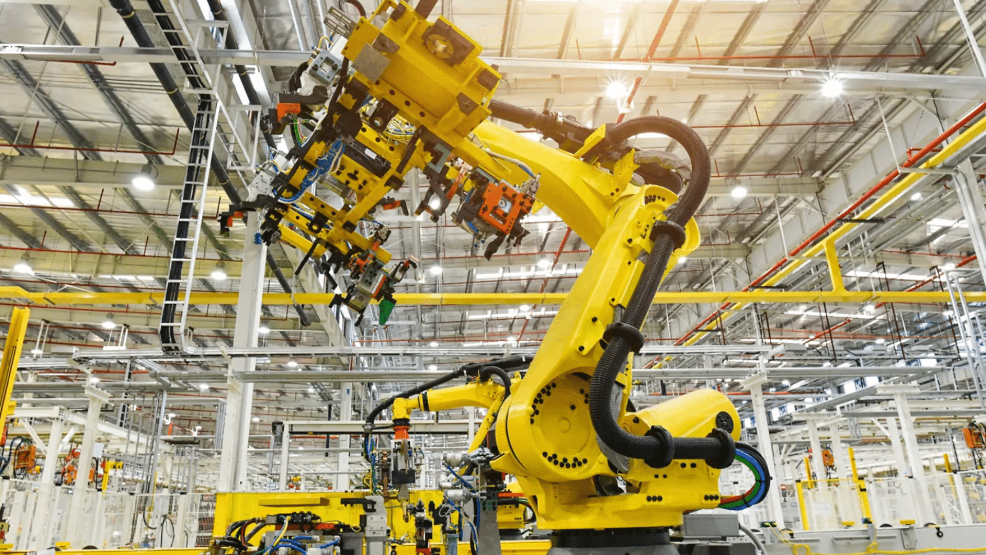 a large yellow robotic arm in a modern factory showcasing robotics and automation on an assembly line