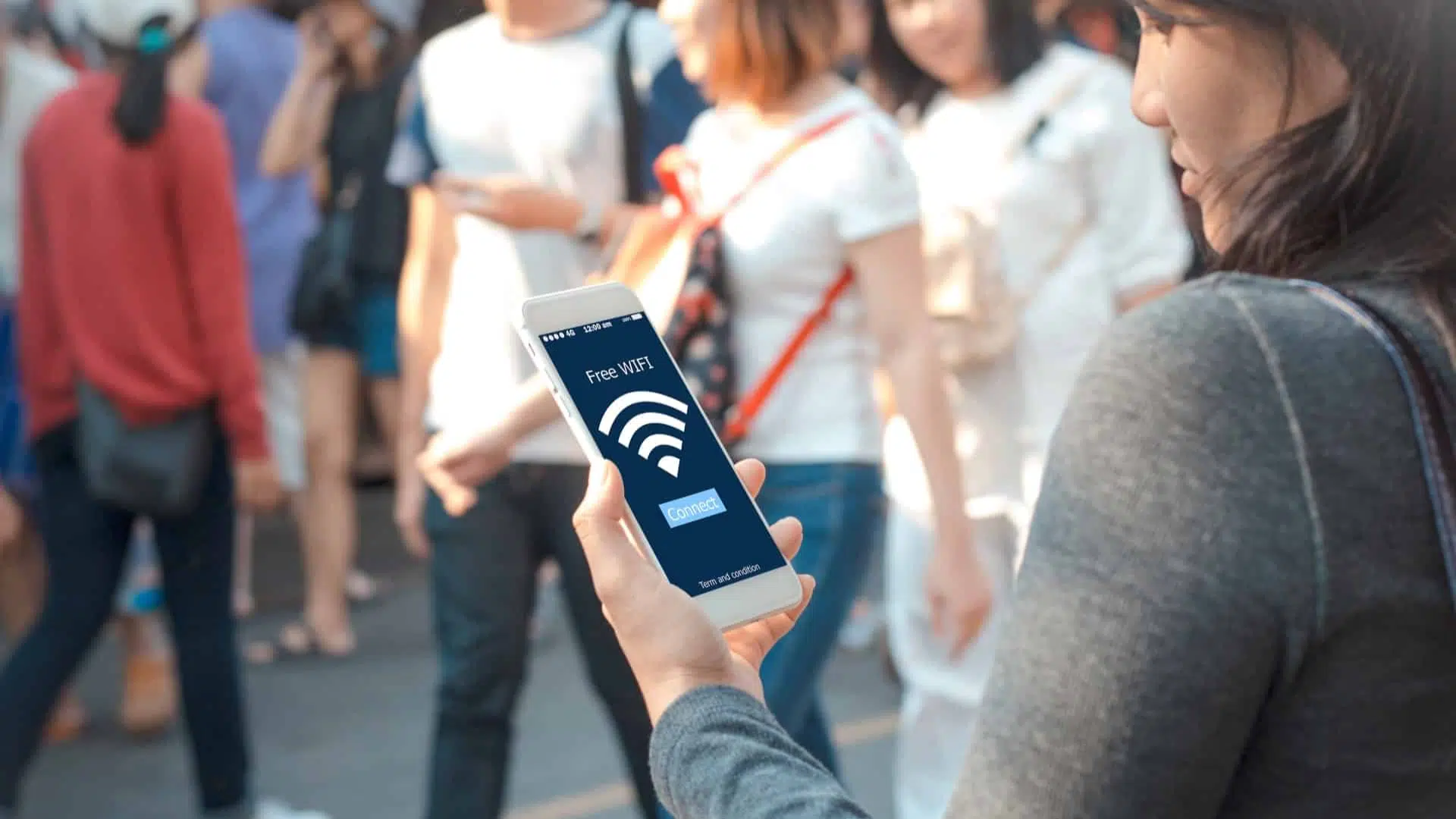 a person connects to free wi-fi in public holding with the wi-fi symbol displayed on her phone