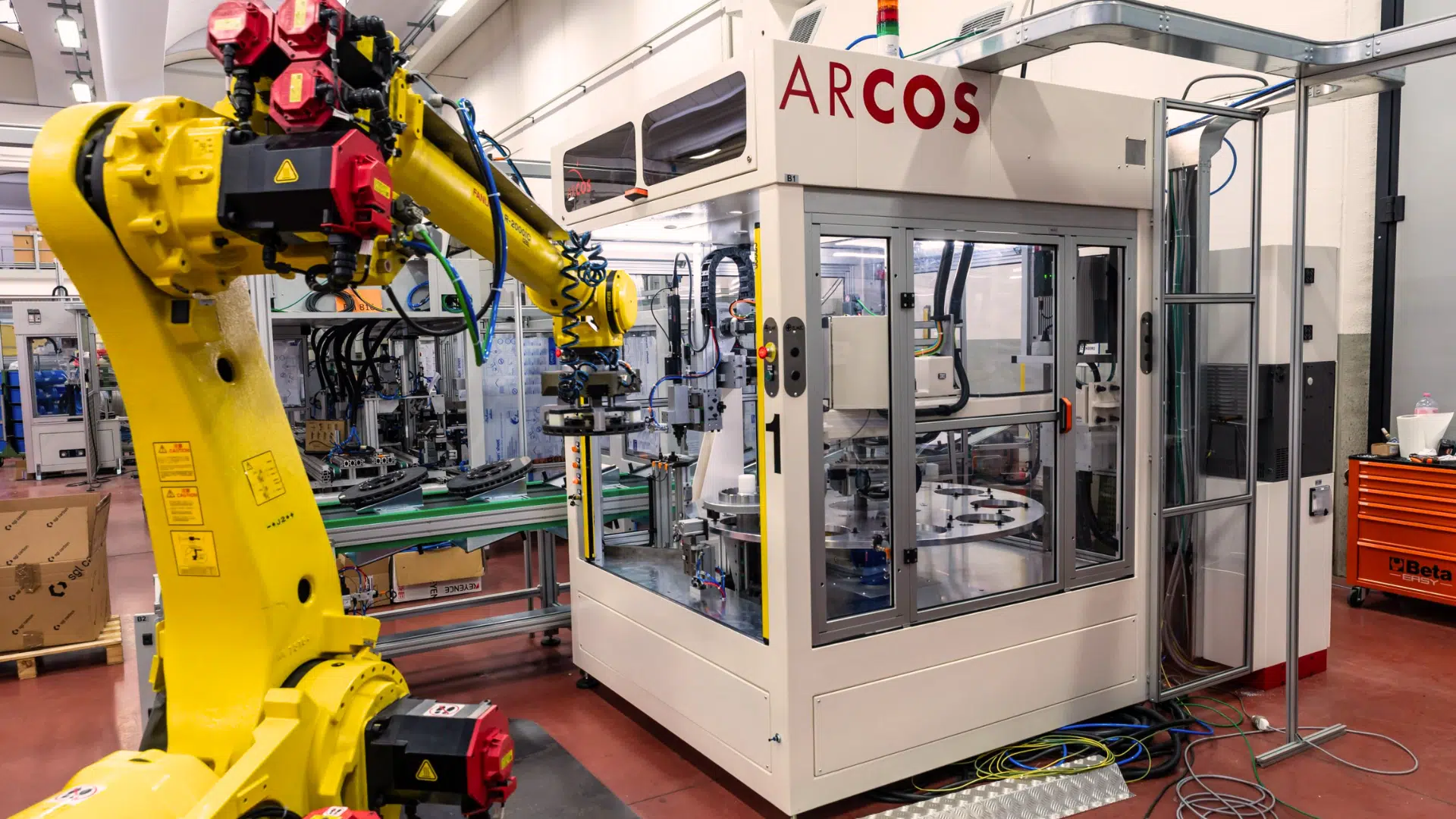 a yellow robotic arm operates near a machine demonstrating robotics and automation in manufacturing