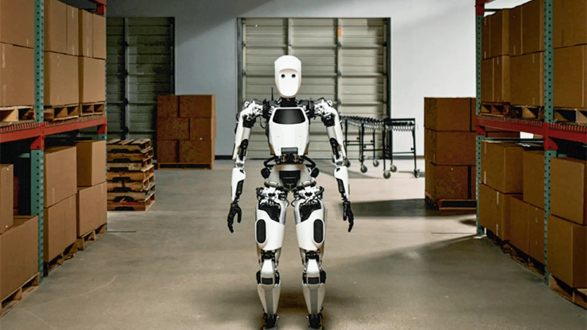 apptronik apollo standing in a warehouse between stacked boxes