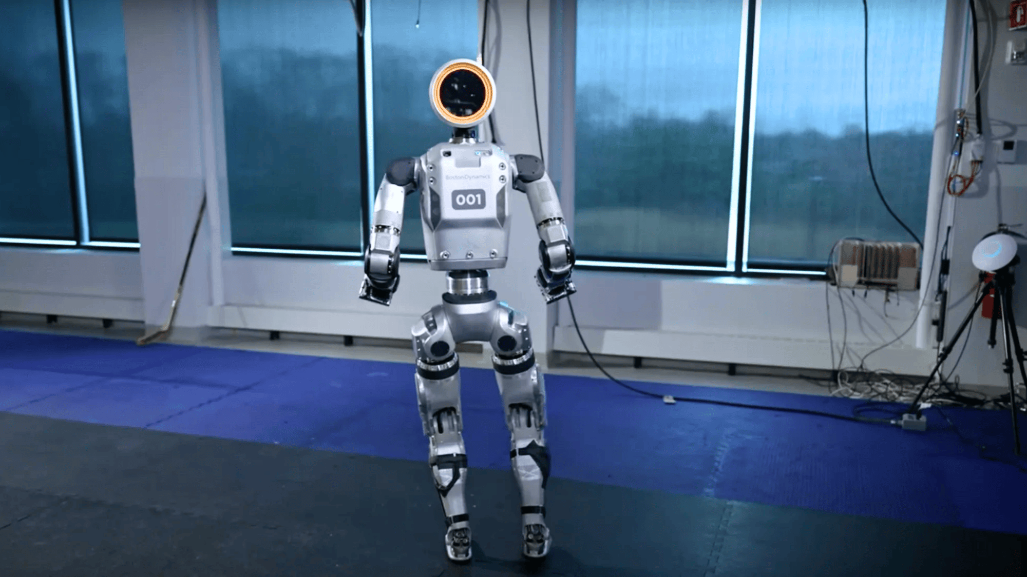 boston dynamics robot with a circular head and standing in a lab environment