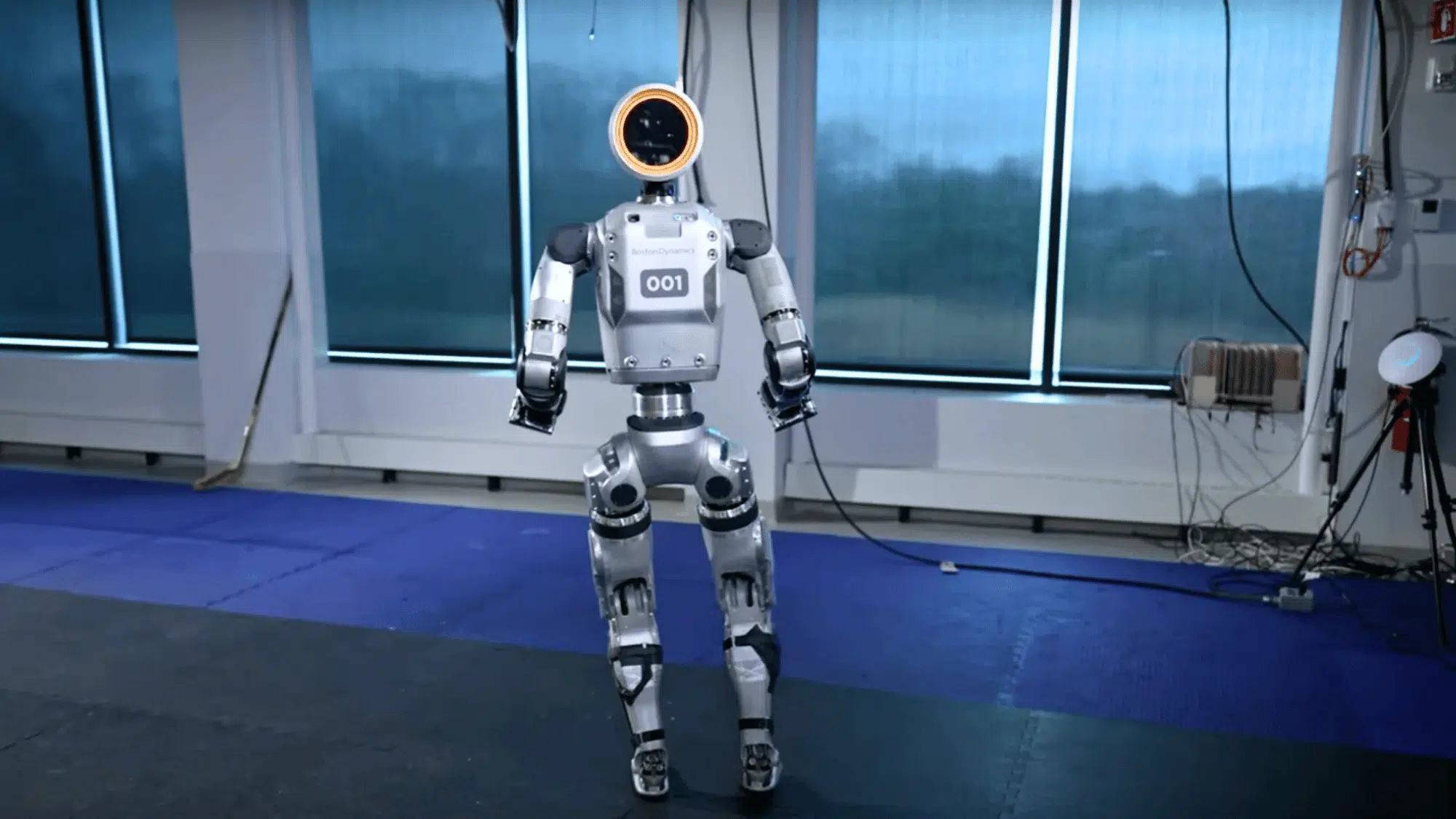 boston dynamics robot with a circular head and standing in a lab environment