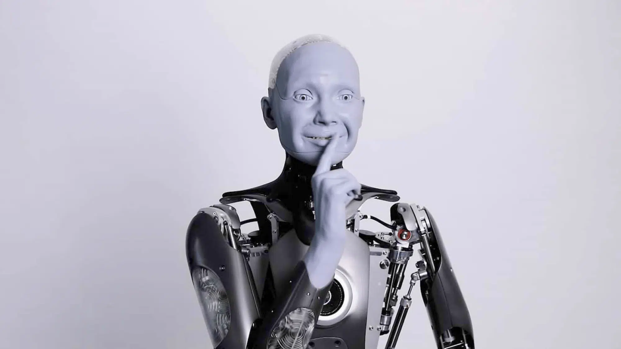 engineered arts humanoid robot smiling and holding its finger to its lips
