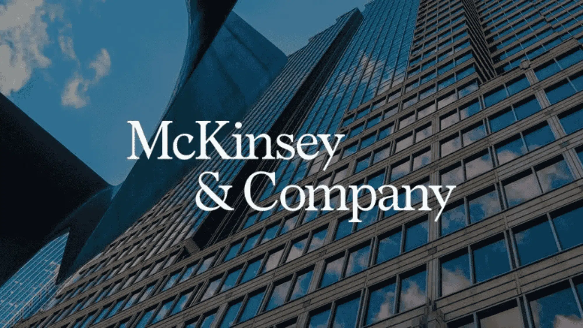 tall glass skyscrapers reflecting clouds with mckinsey & company logo in white
