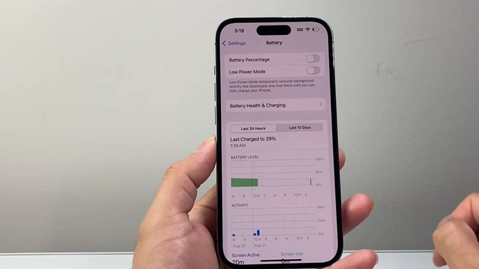 a hand holding an iphone displaying battery settings with low power mode toggle turned off on the screen