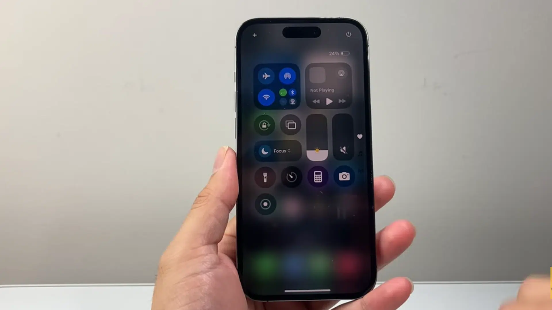 a hand holding an iphone displaying control center settings with wifi and cellular data control on screen