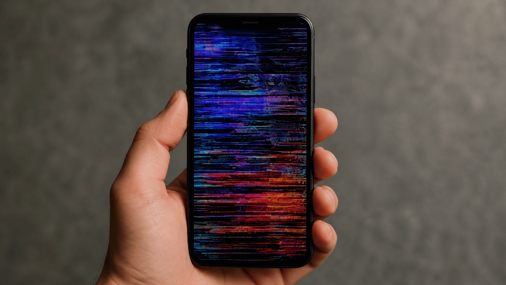 hand holding smartphone with colorful screen glitch showing horizontal digital distortion against blurred background