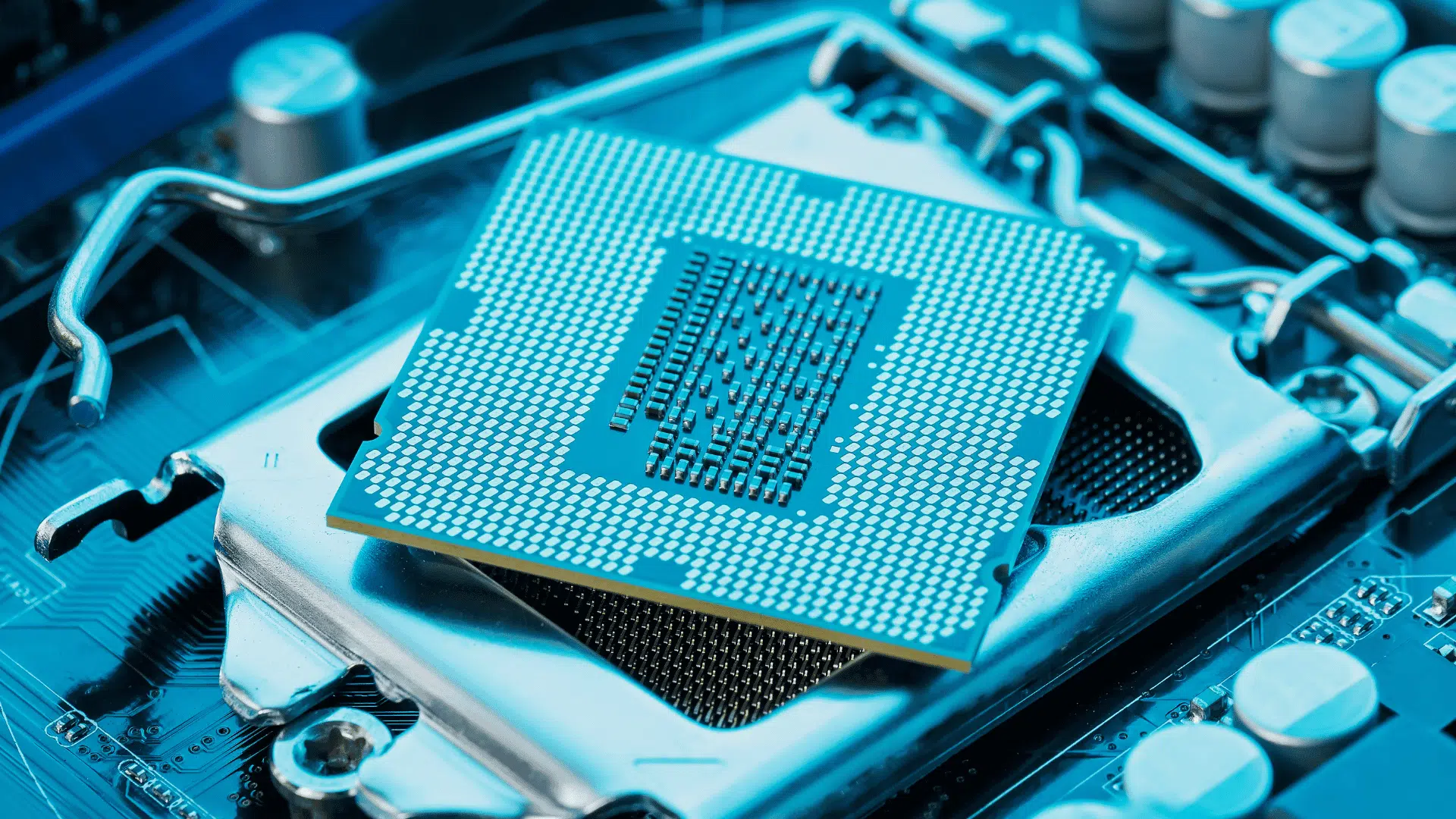 close up of a computer processor seated in a motherboard socket surrounded by electronic components and metal retention bracket