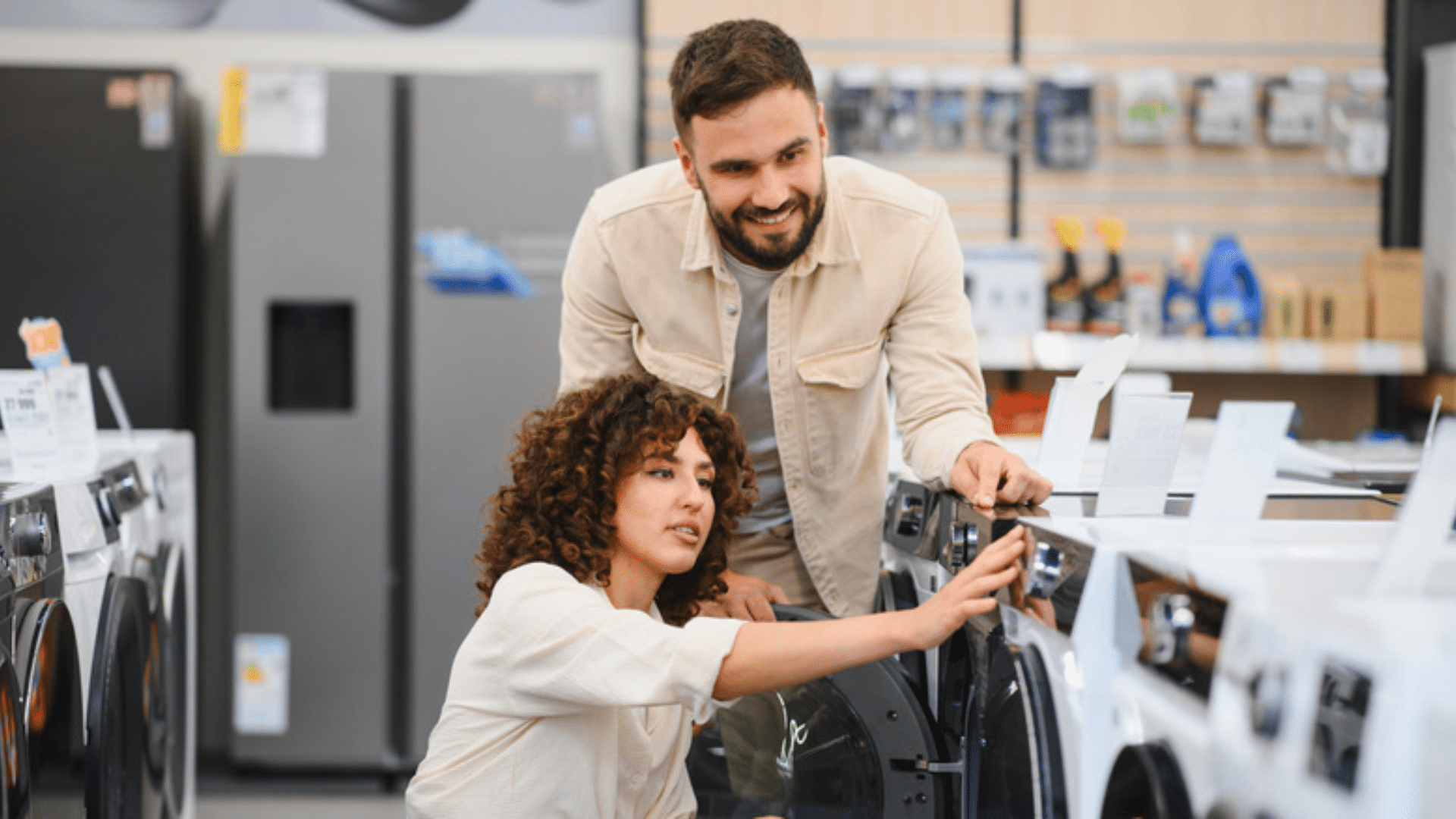 comparing washing machines in an appliance store while shopping for new home appliances during sales