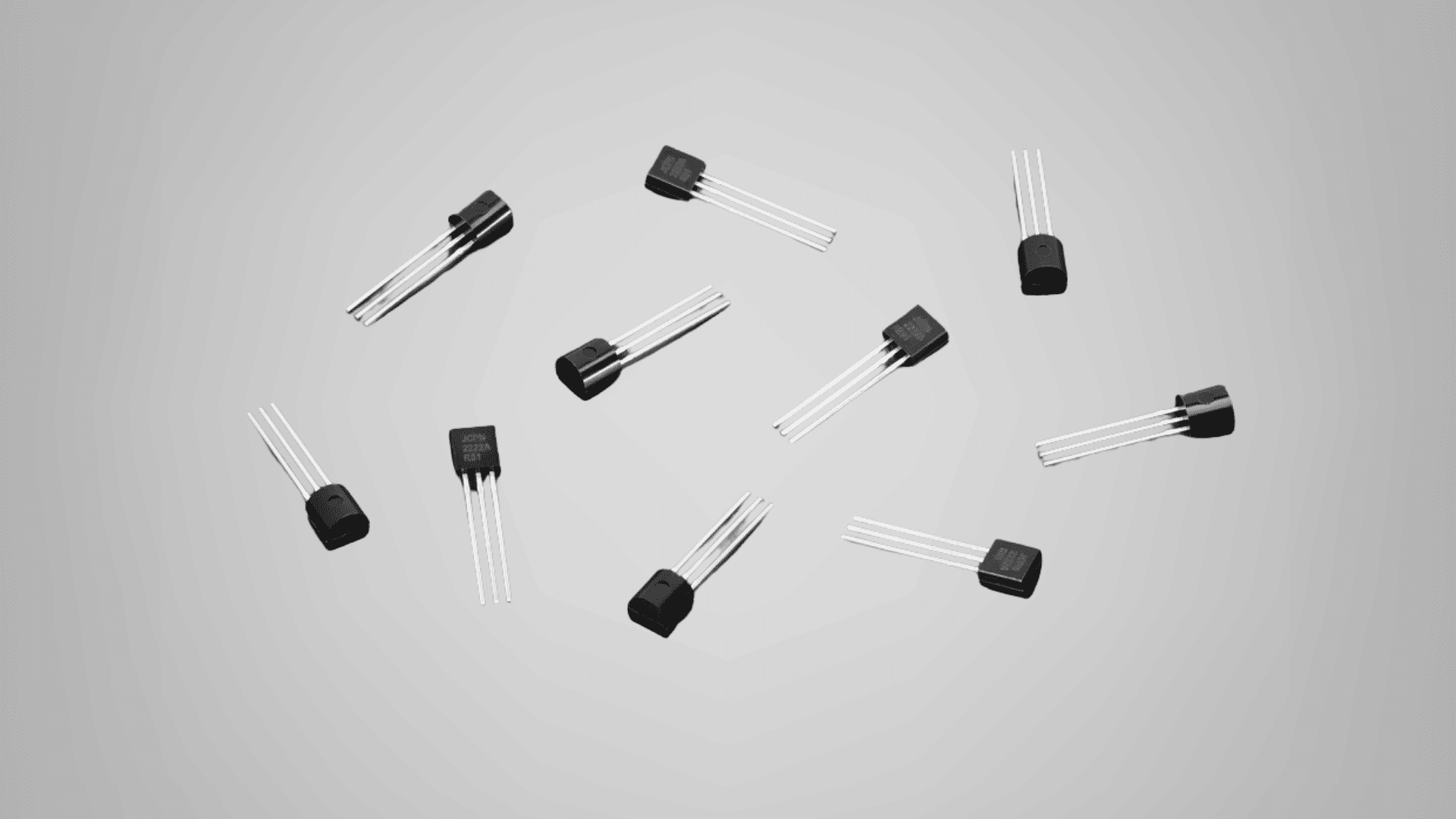 Black semiconductor transistors with three metal leads on a gray background