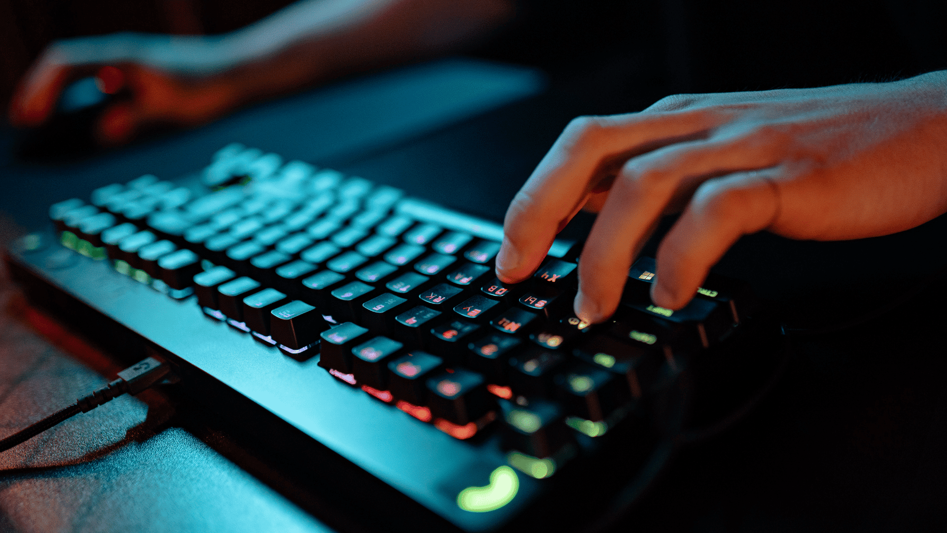 hand using an illuminated gaming keyboard during online gameplay