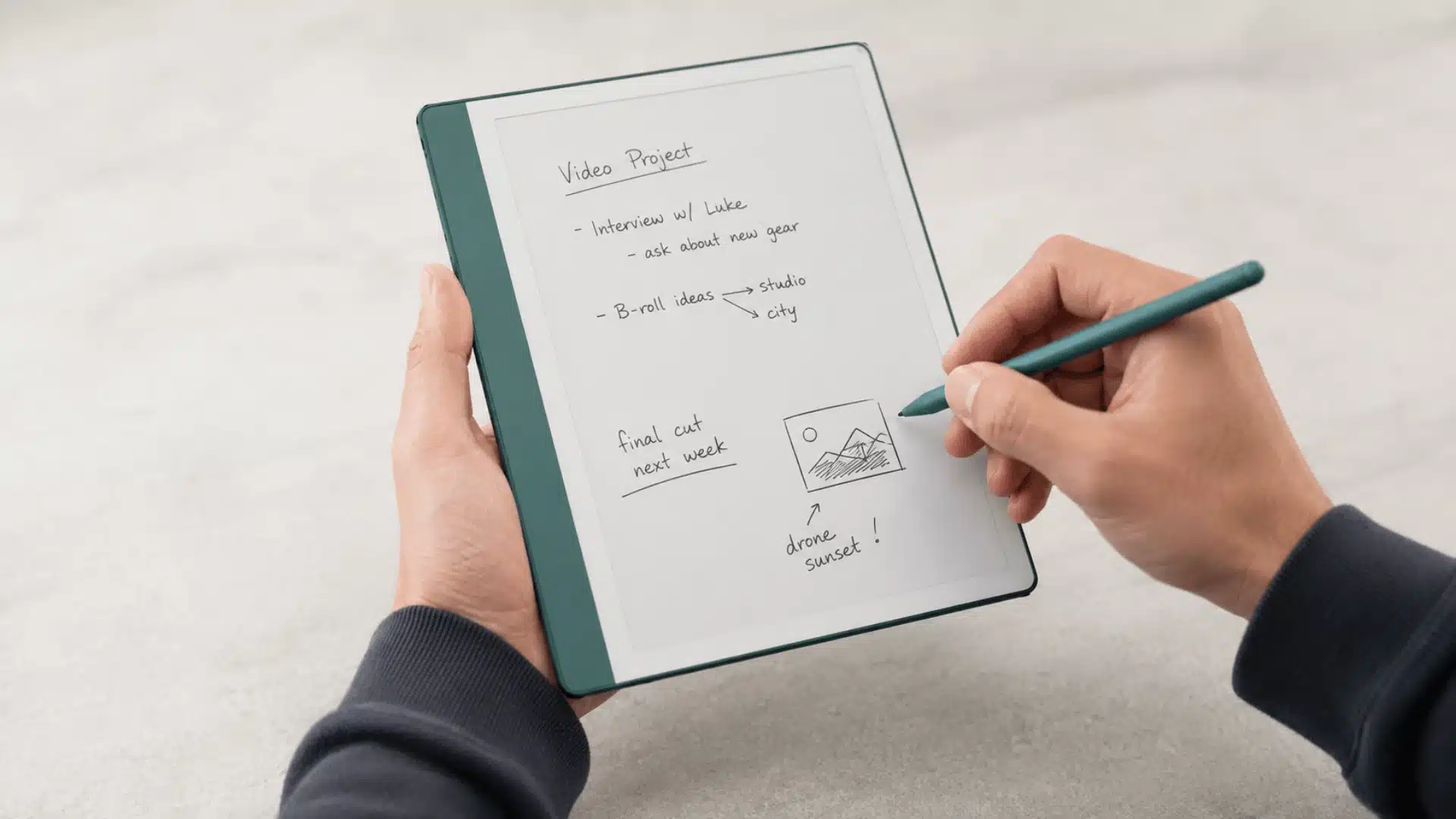 kindle scribe style e ink tablet with teal cover and handwritten notes on screen with stylus