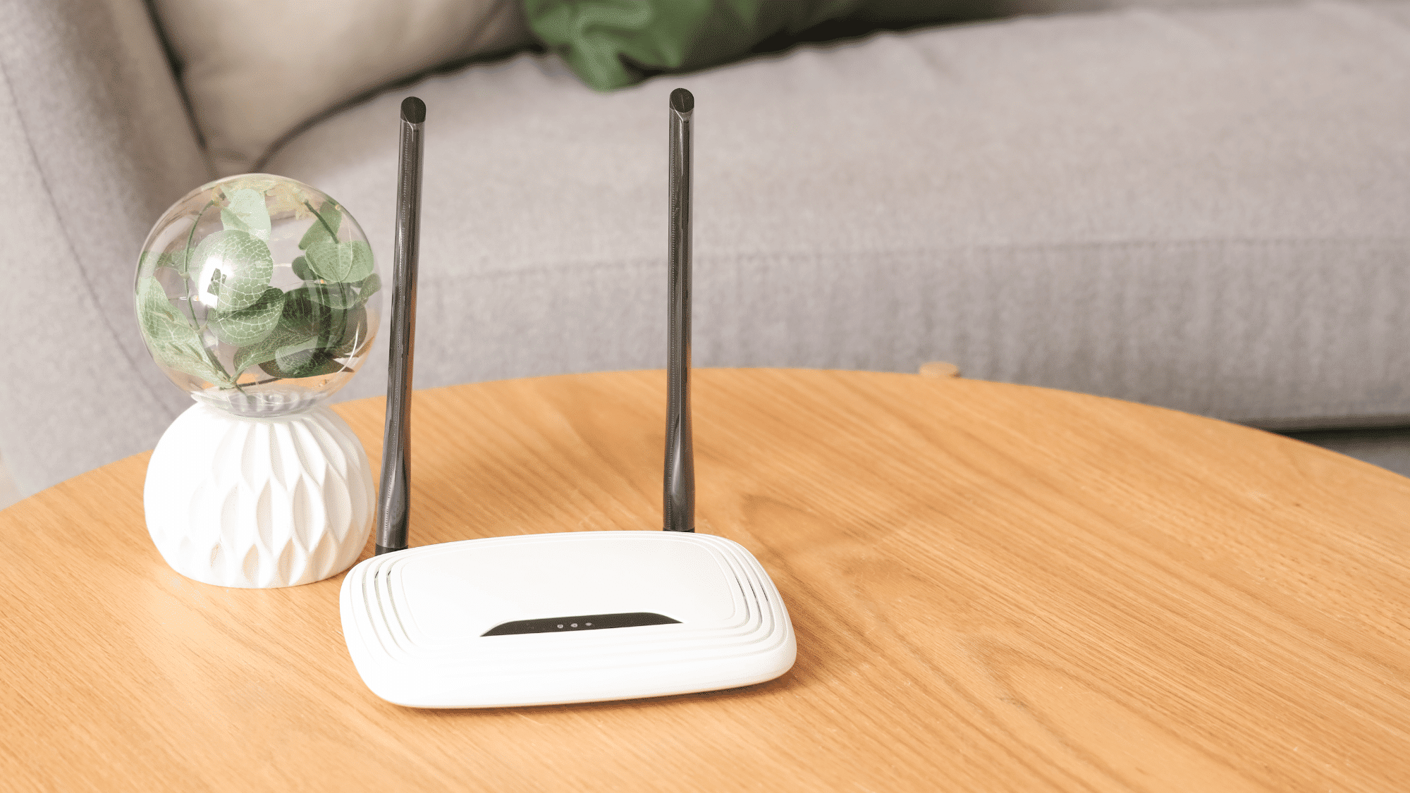 white wifi router with antennas placed on a wooden table in a home setting for wireless network connection