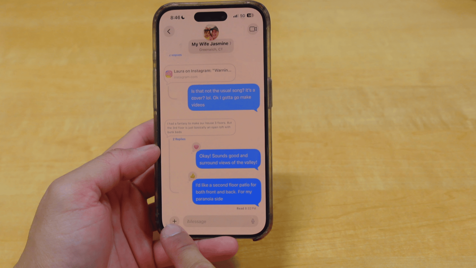 person holding an iphone with an imessage conversation open and tapping the plus button to access message options