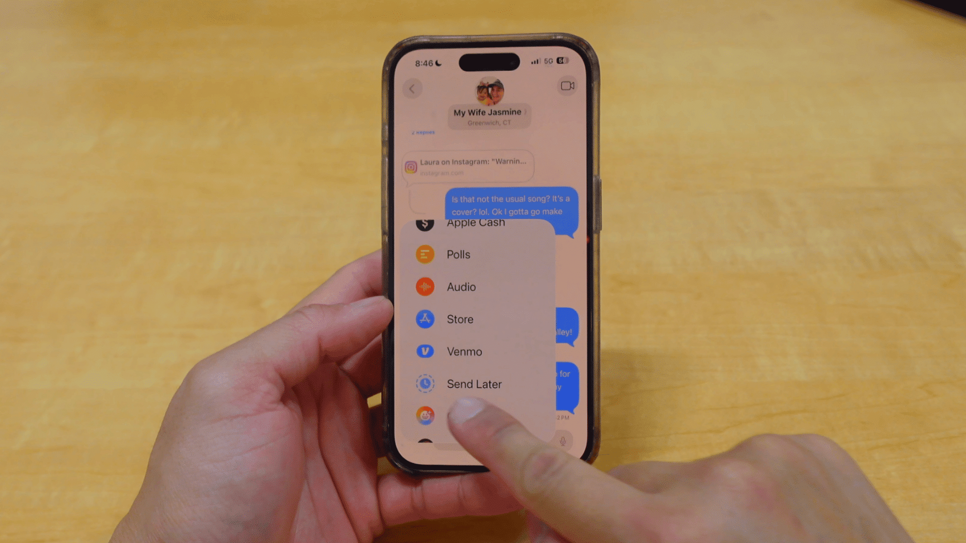 person selecting the send later option from the imessage attachment menu while viewing a conversation on an iphone
