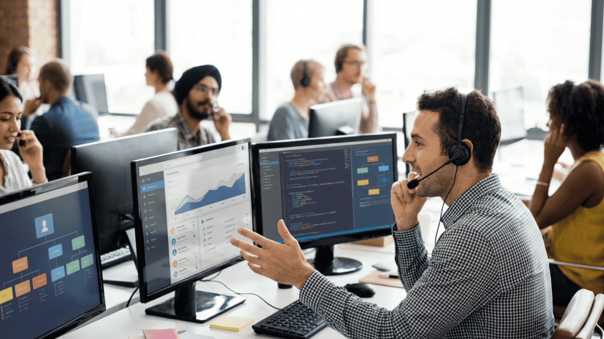 customer support workers using headsets and computer screens in a busy modern office space